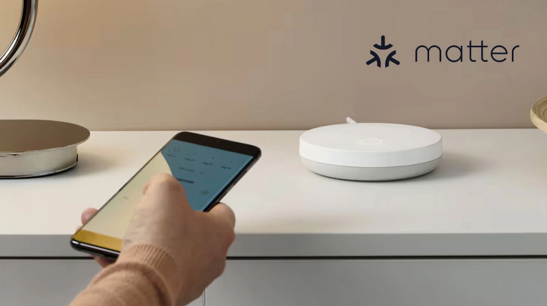 Weißer IKEA DIRIGERA Hub auf einer Kommode, davor eine Hand mit Smartphone, oben rechts das Matter-Logo