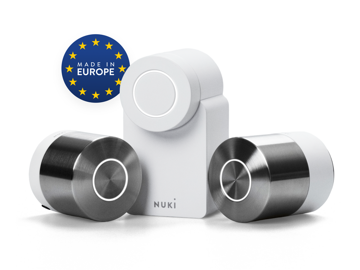Drei Nuki Smart Locks der 5. Generation nebeneinander, weiß und in Edelstahl, mit dem Siegel Made in Europe