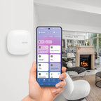 Der Hub an der Wand montiert, daneben ein Smartphone mit der App