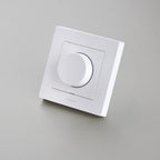 Weißer Aqara Dimmer H2 leicht gekippt vor hellgrauem Grund, mit Aqara-Schriftzug unter dem Knopf