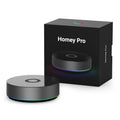 Athom Homey Pro als runder schwarzer Hub neben seiner Verpackung