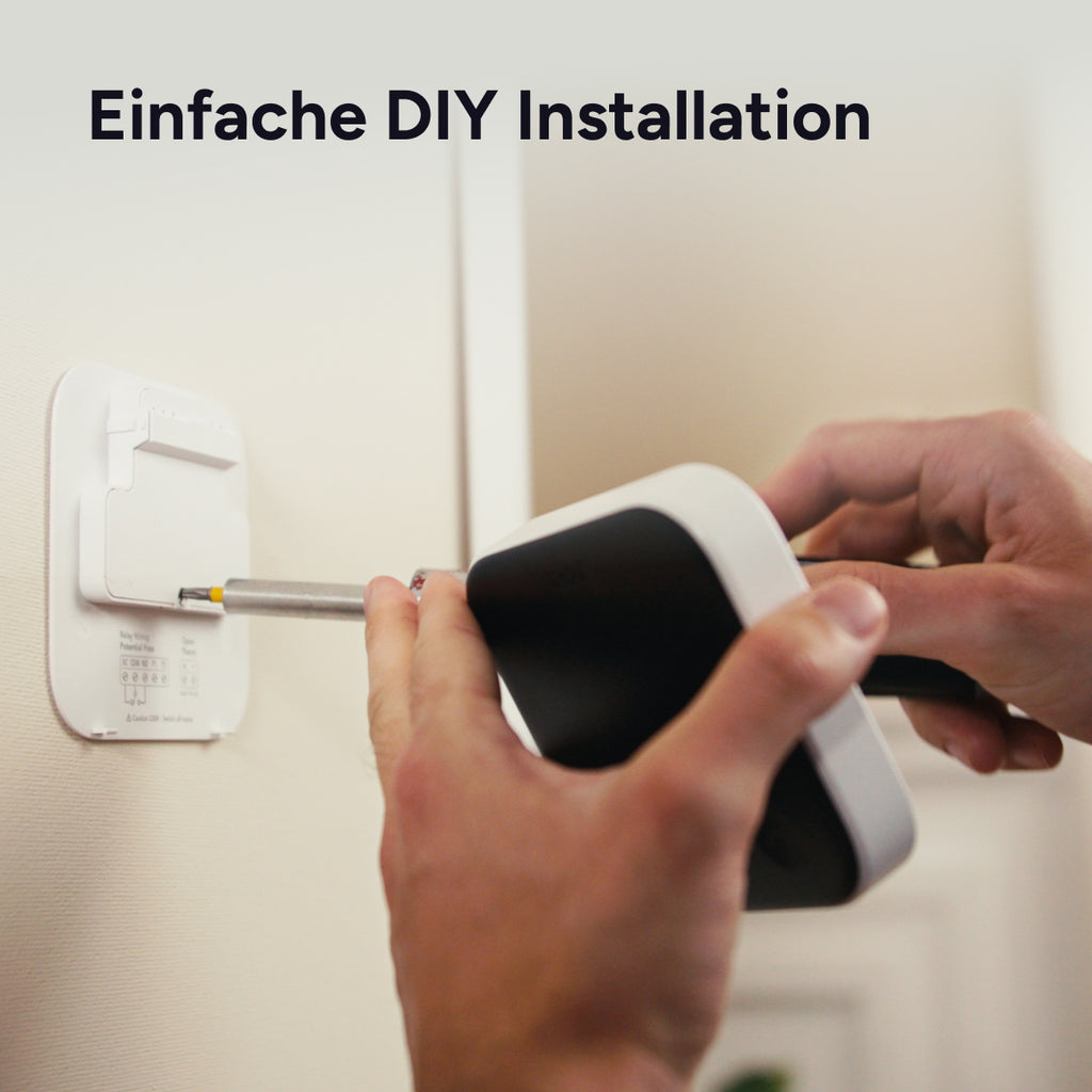Hände schrauben das Smarte Thermostat X auf die Wandhalterung, Schriftzug Einfache DIY Installation