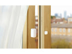Eve Door & Window am Holzrahmen eines Fensters, Magnetteil auf dem Flügel, Stadtblick dahinter