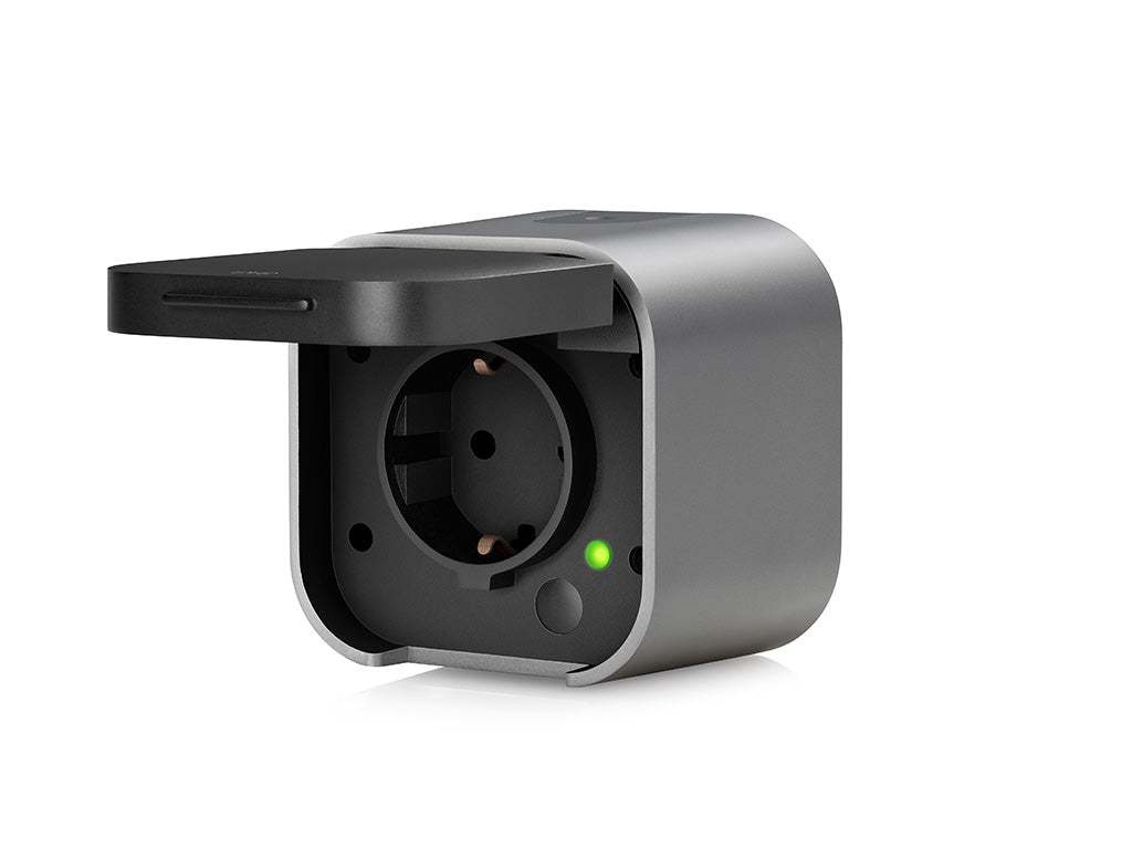Eve Energy Outdoor mit geöffneter Klappe, Schuko-Buchse, Taste und grün leuchtender LED