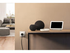 Eve Energy in der Wandsteckdose neben einem Sideboard mit Smart-Speakern und Display