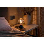 Hama Retro-LED Lampe E27 Globe warmweiß in einer schwarzen Tischleuchte am Bett