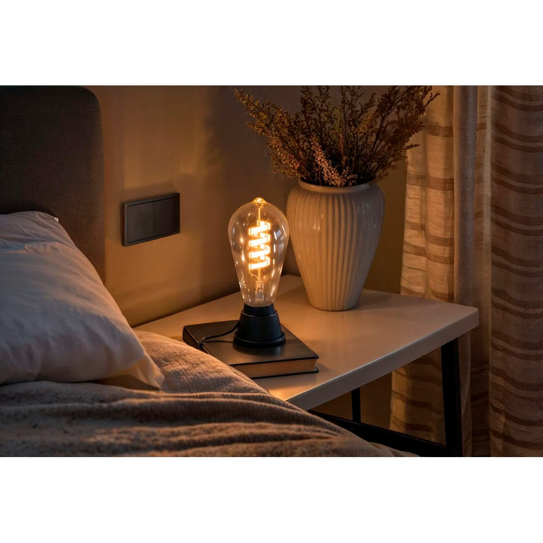 Hama Retro-LED Lampe E27 warmweiß in einer schwarzen Tischleuchte auf dem Nachttisch
