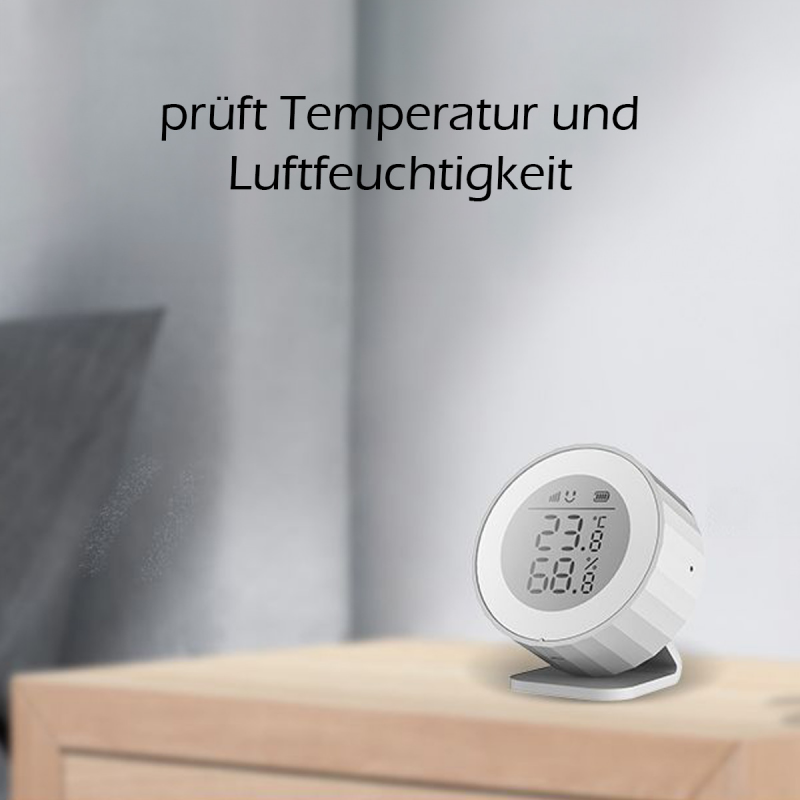 Heiman H1-M auf einer Holzkommode, Wasserdampf im Hintergrund, Text im Bild: prüft Temperatur und Luftfeuchtigkeit