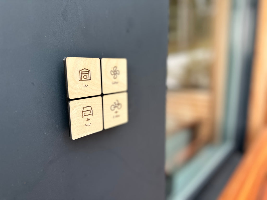Lichtschalter in hellem Holz mit gravierten Symbolen neben einem Fenster