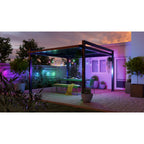 Terrasse mit Pergola, Nanoleaf Outdoor Light String färbt Wände und Pflanzen grün, pink und violett