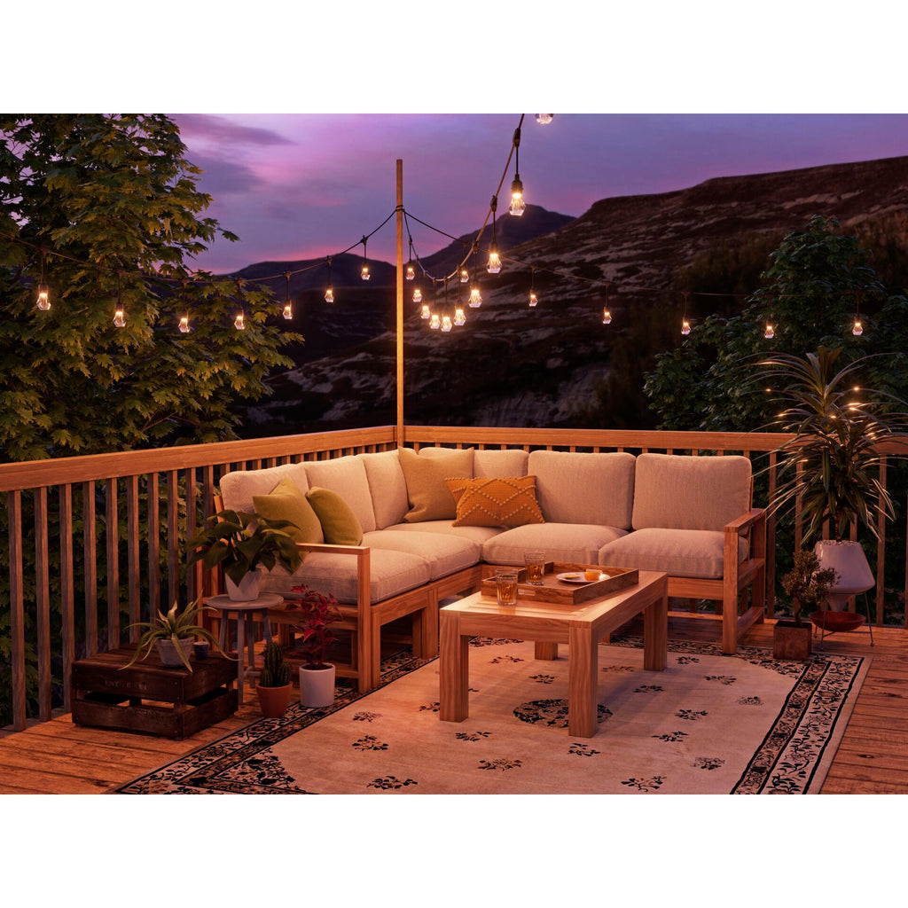 Nanoleaf Outdoor Light String warmweiß über Ecksofa auf einer Holzterrasse mit Bergpanorama