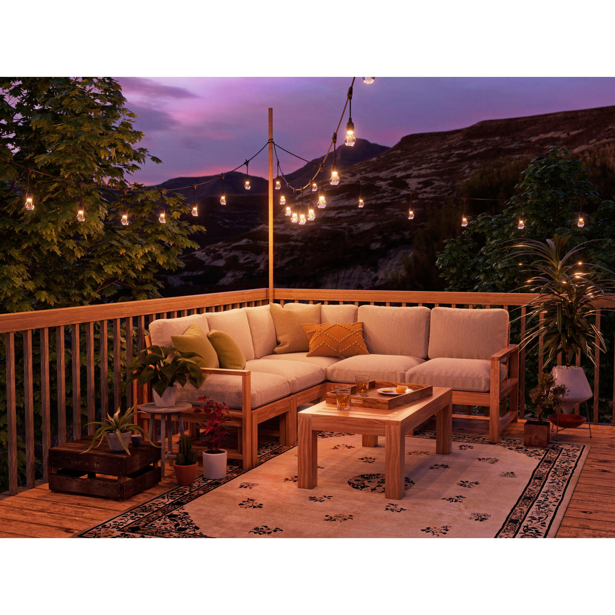 Nanoleaf Outdoor Light String warmweiß über Ecksofa auf einer Holzterrasse mit Bergpanorama