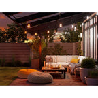 Warmweiß leuchtendes Nanoleaf Outdoor String Light über Loungesofa und Sitzkissen bei Sonnenuntergang