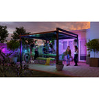 Gartenparty unter Pergola, Nanoleaf Outdoor String Light leuchtet grün und pink, Menschen tanzen auf der Terrasse