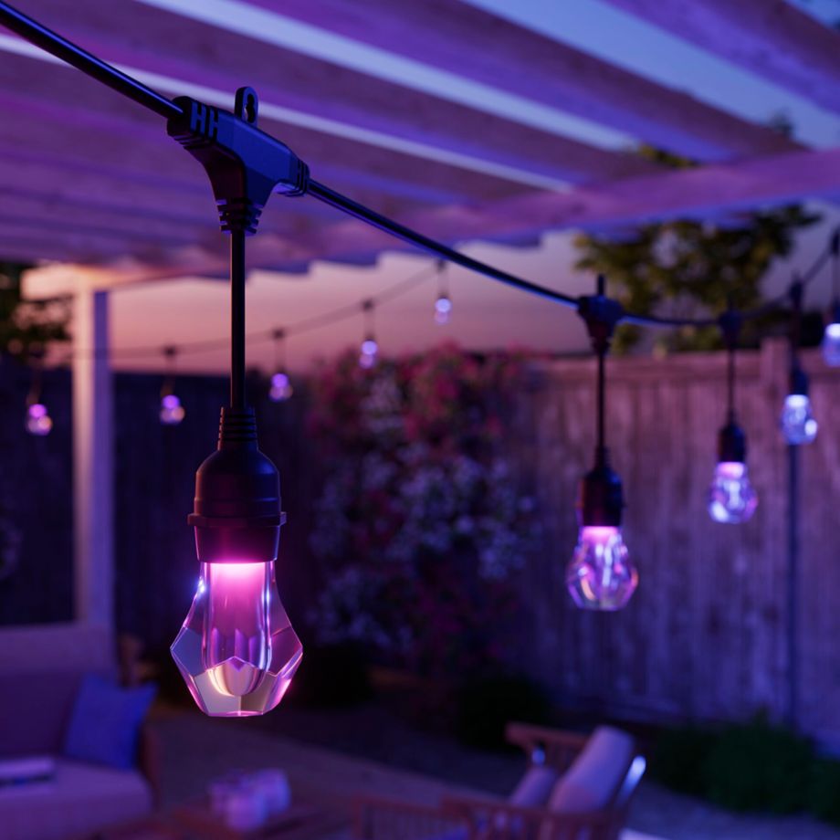 Nahaufnahme einer pink leuchtenden Birne des Nanoleaf Outdoor String Light, weitere Lichter unscharf dahinter