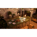 Nanoleaf Outdoor String Light über einem gedeckten Gartentisch mit Brot und Wein auf der Holzterrasse