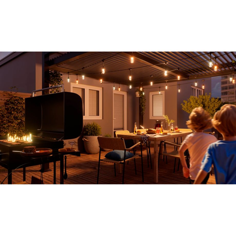 Nanoleaf Outdoor String Light über einer Dachterrasse mit Grill und Esstisch, zwei Kinder laufen vorbei