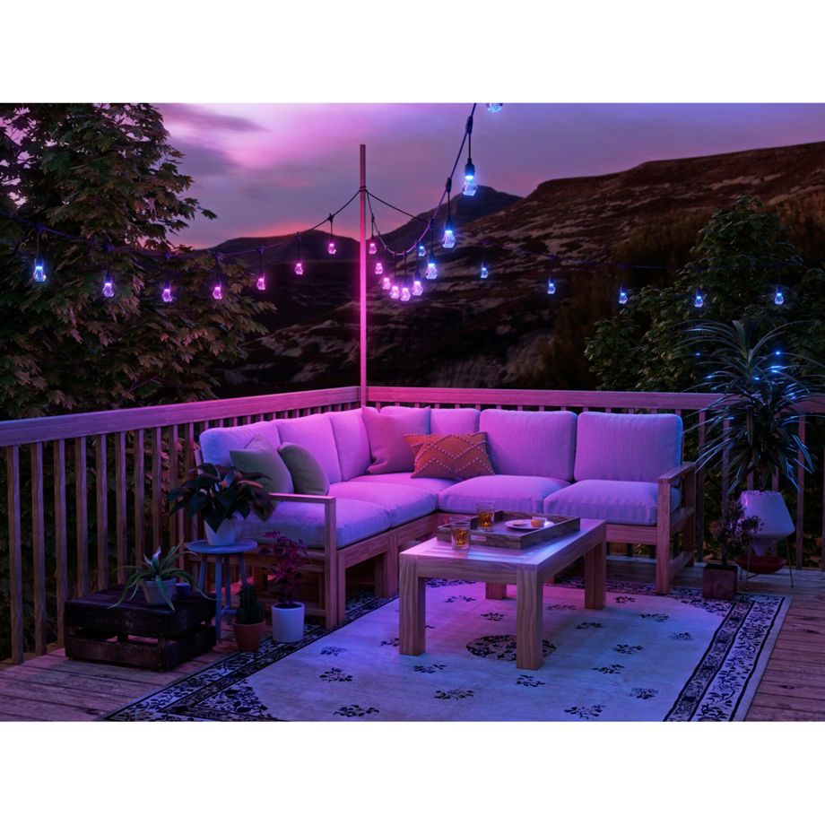 Nanoleaf Outdoor String Light in Pink und Blau über dem Ecksofa einer Terrasse vor Bergpanorama