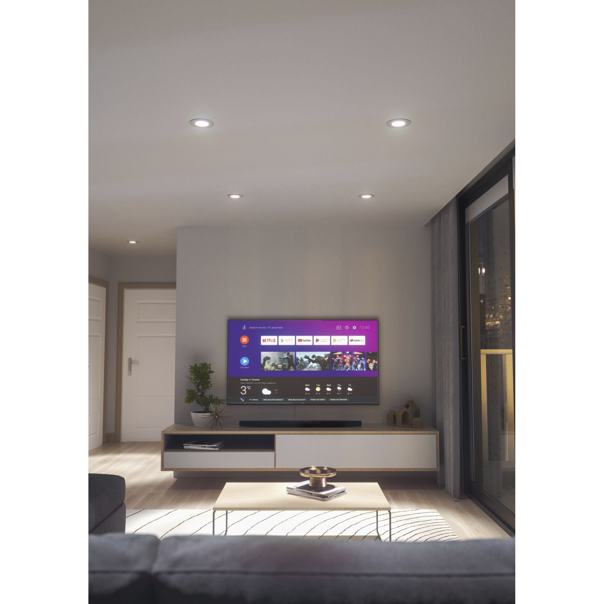 Wohnzimmer mit TV-Wand, vier Nanoleaf Smart Spots leuchten weiß und rosa in der Decke