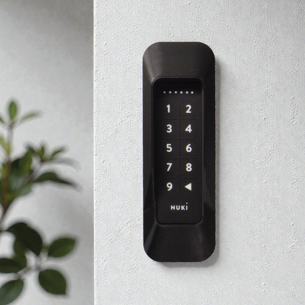 Das Keypad 1 im Rahmen an einer Wand neben einer Grünpflanze