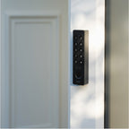 Nuki Keypad 2 NFC seitlich am schmalen Rahmen einer hellen Tür montiert, im Streiflicht fotografiert