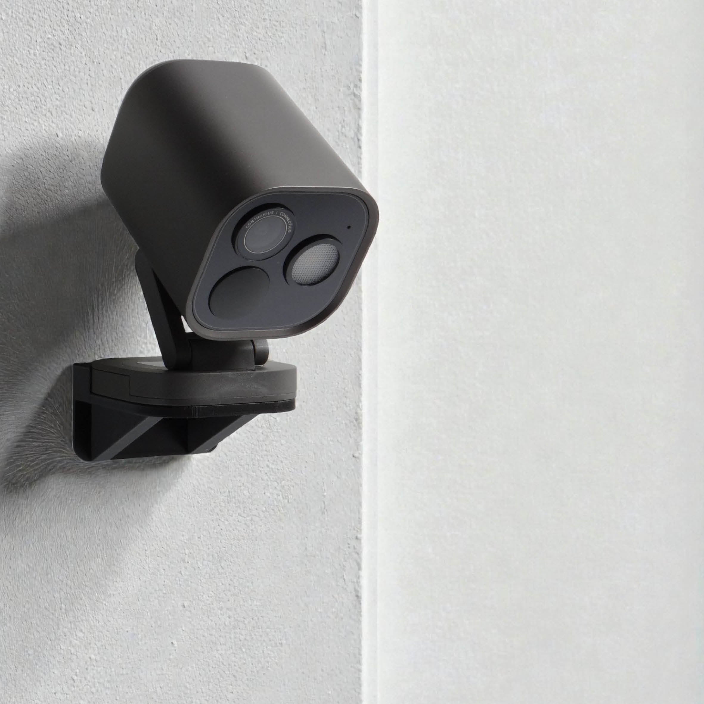 Schwarzer Camera Hub G5 Pro in der Wandhalterung an einer hellen Wand