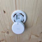 Abgenommener FP2 neben der offenen runden Halterung an der Holzwand