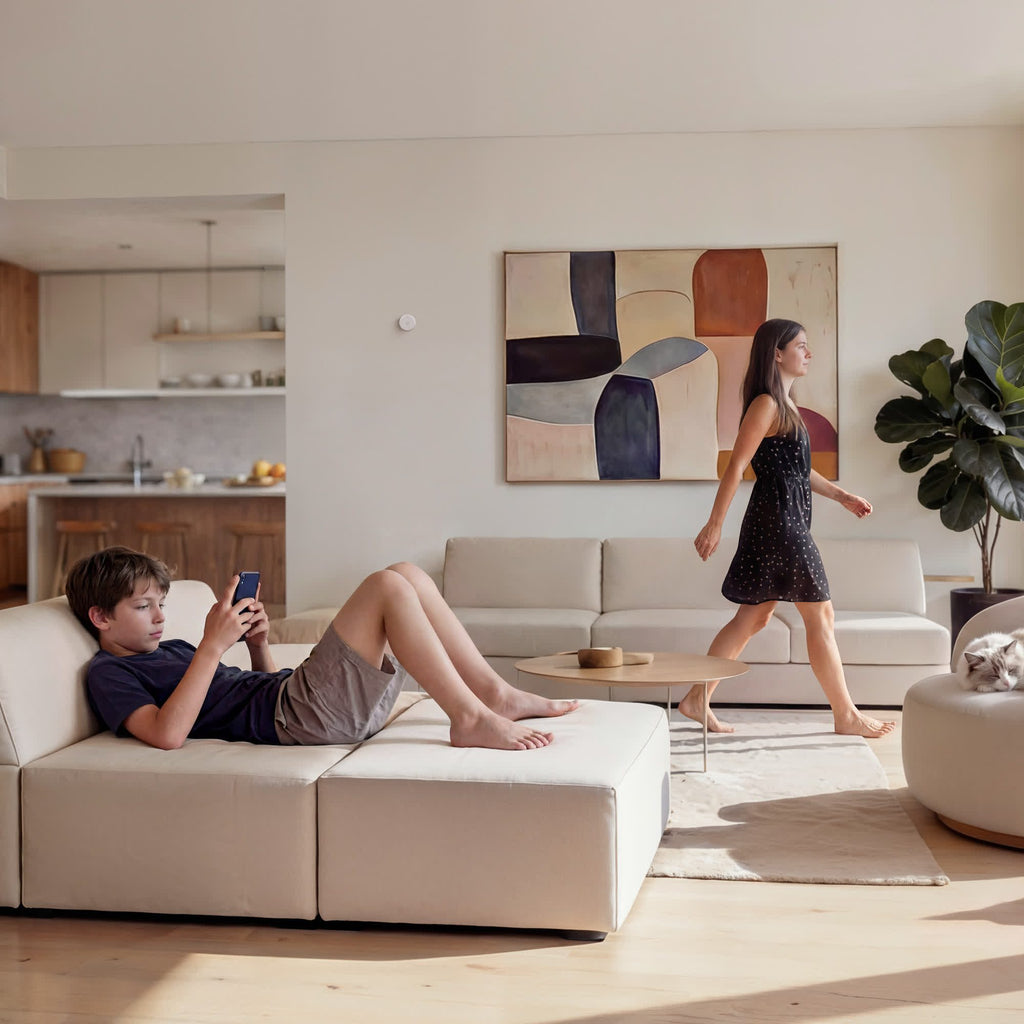 Wohnzimmer mit Aqara Spatial Multi-Sensor FP400 an der Wand, zwei Kinder und eine Katze im Raum