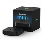 Homey Pro mini als flacher schwarzer Quader neben seiner Verpackung