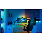 Gaming-Schreibtisch mit Lightstrip hinter Monitor und Regal, Raum in Blau und Grün