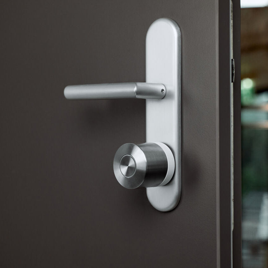 Nuki Smart Lock Ultra mit hellem Basisring an einer dunkelbraunen Tür, die einen Spalt offen steht