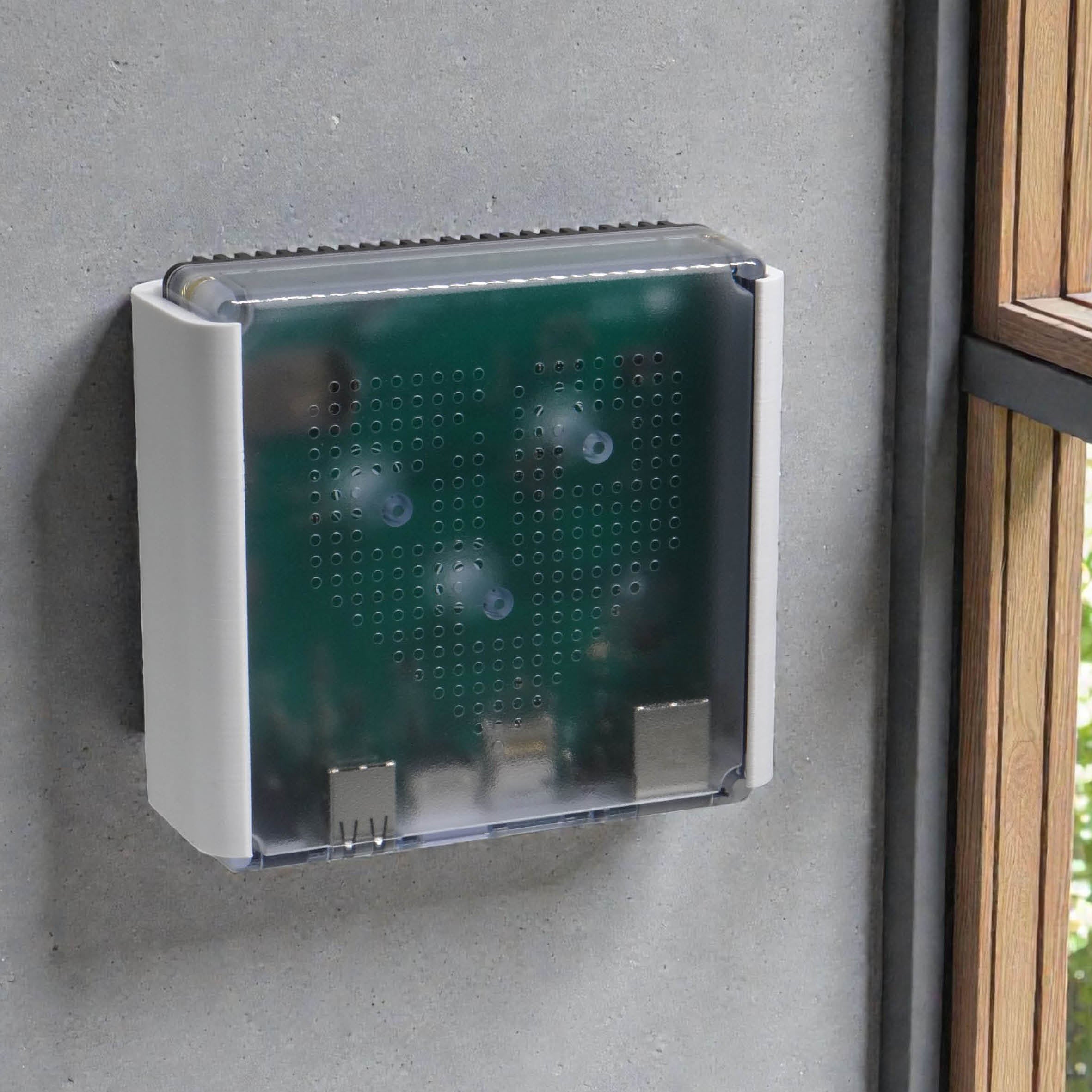Home Assistant Green in der Wandhalterung an einer Wand montiert