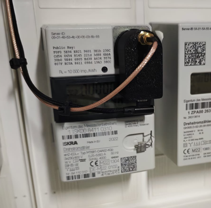 Lesekopf am Zähler, die Antenne hängt an einem Koaxkabel neben dem Gerät statt direkt am Anschluss