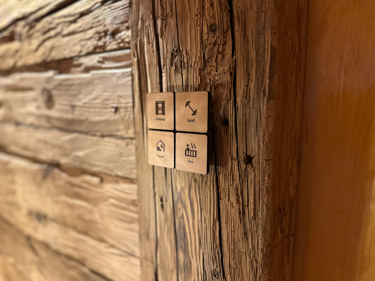 Lichtschalter mit gravierten Symbolen an einer verwitterten Holzwand