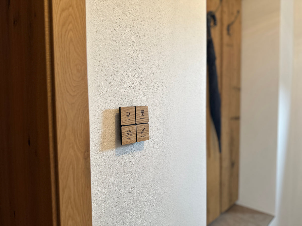 smattex Lichtschalter aus Eiche mit vier gravierten Symbolen an einer weißen Flurwand neben Holzvertäfelung
