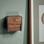 Fernbedienung aus Nussbaum in der Wandhalterung an grüner Wand neben einem gerahmten Bild