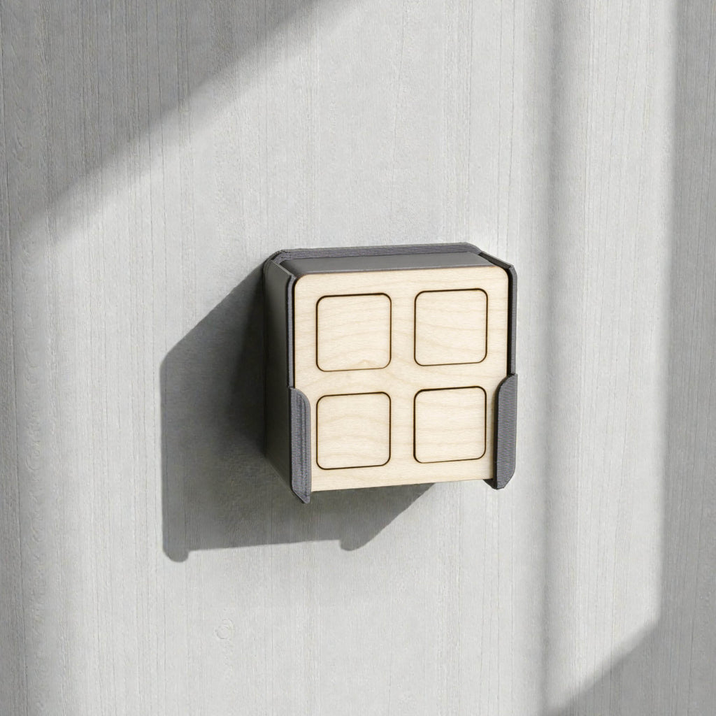 Fernbedienung aus Ahorn in der Wandhalterung an heller Holzwand, Sonnenlicht wirft einen Schatten