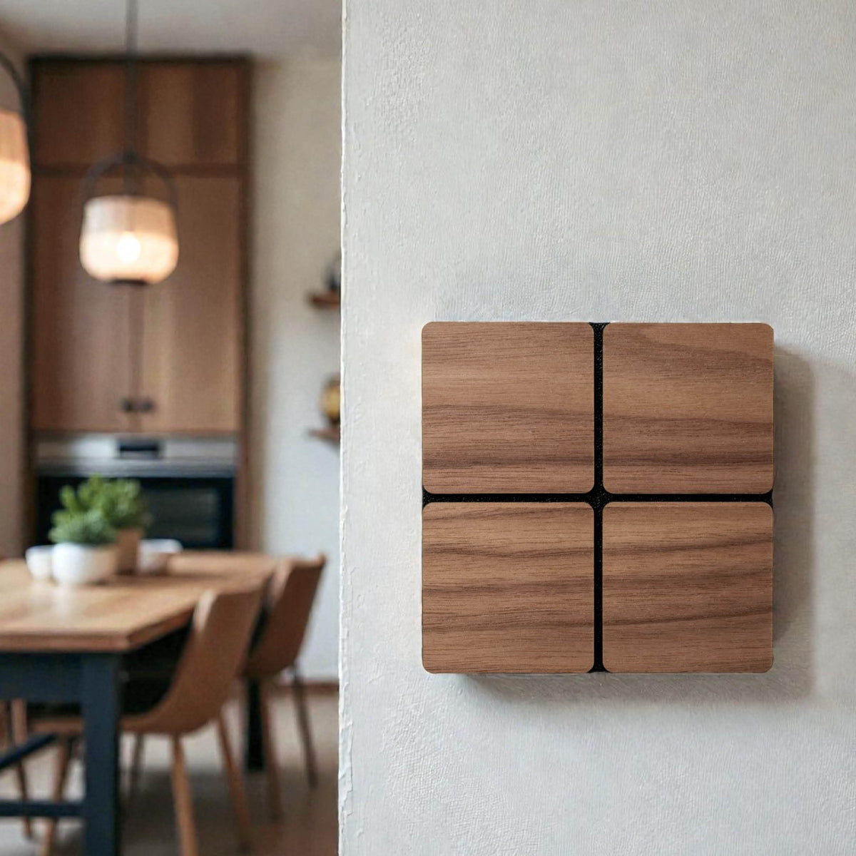 Lichtschalter aus Nussbaum an weißer Wand, im Hintergrund unscharf eine Küche mit Esstisch