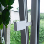 Tarken WM am Flügel eines weißen Kunststofffensters, der Arm reicht zum Anker am Rahmen, das Fenster steht offen
