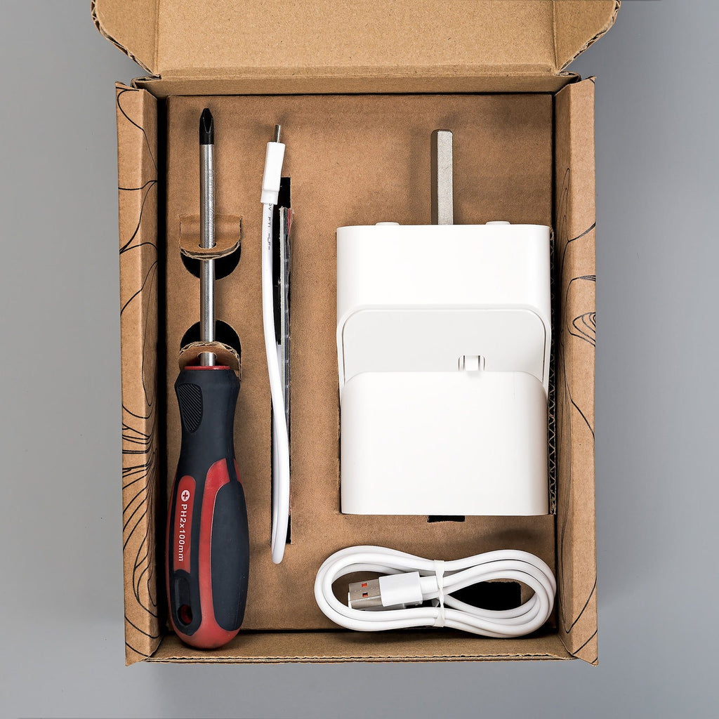 Lieferumfang des Tarken WM im Karton: Fensterantrieb, Solarpanel, USB-C-Ladekabel und Kreuzschlitz-Schraubendreher
